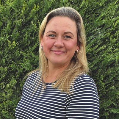 Headshot of a woman with blonde shoulder-length hair smiling to camera.